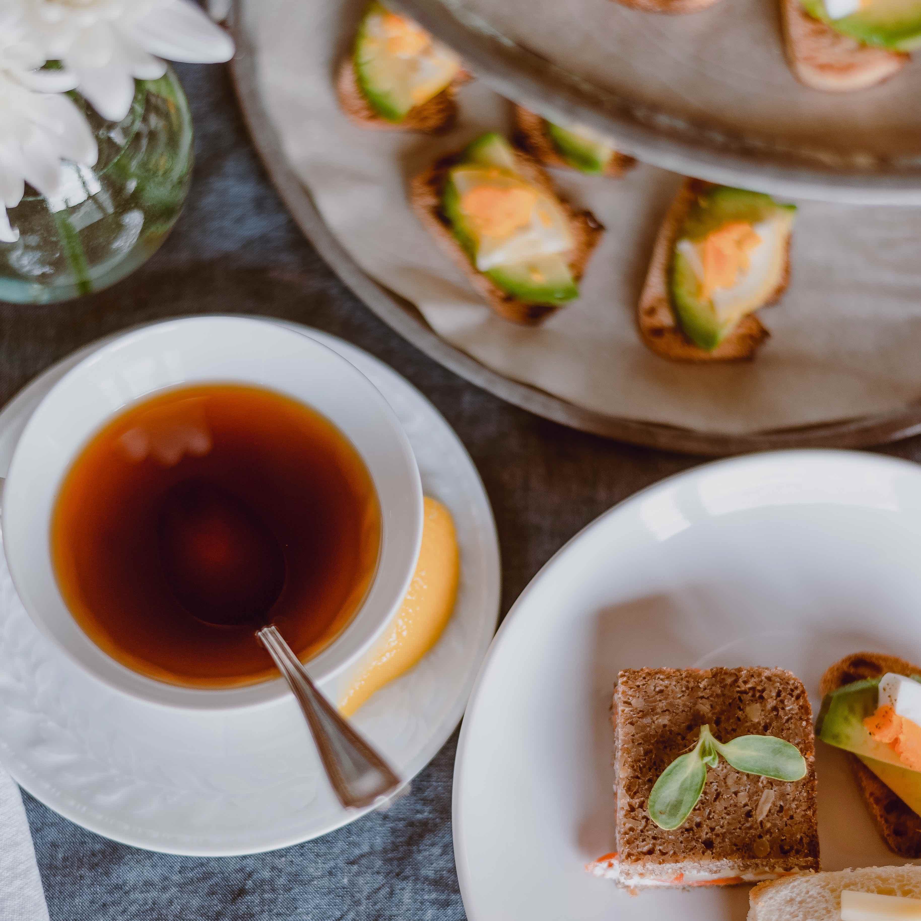 A cup of tea with various finger sandwiches.