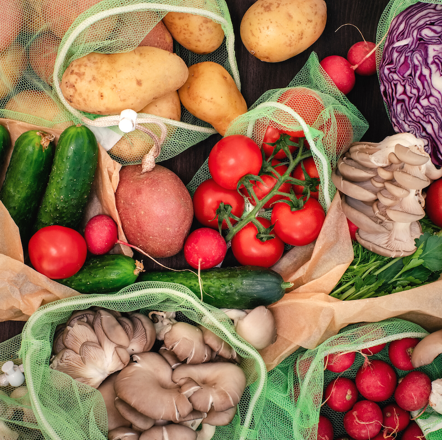 A variety of fruits and vegetables in reusable and recyclable bags.