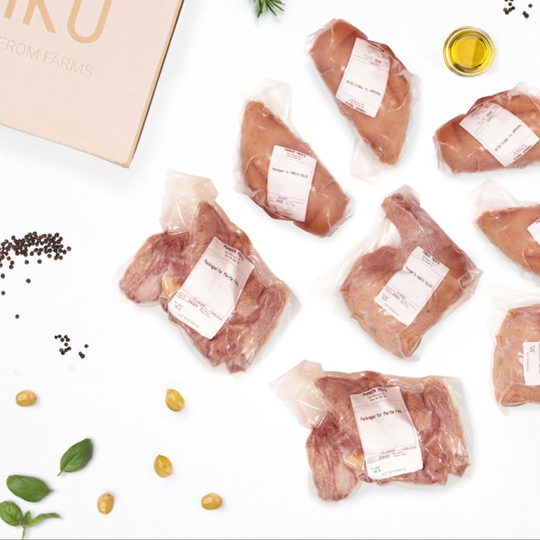 A NIKU Farms box with various cuts of frozen duck next to it.