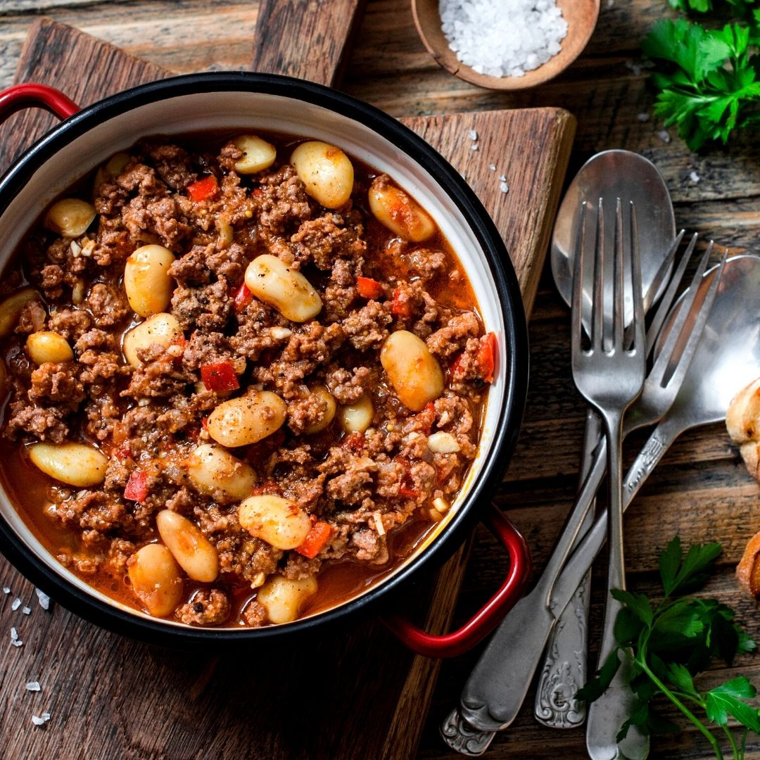 Beef and potato stew in a large pot, with forks and spoons to feed the family.