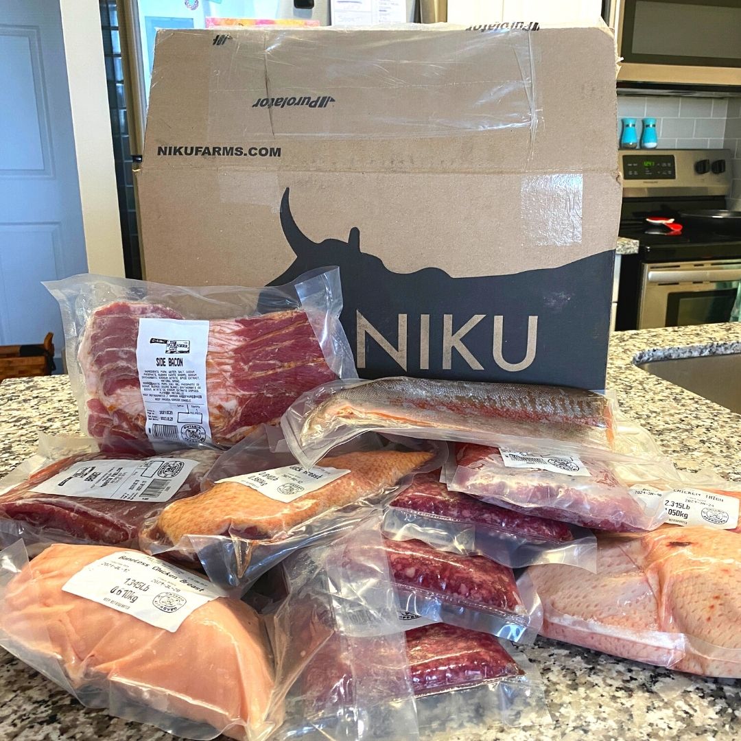 A NIKU Farms meat subscription box with a variety of pasture raised and grass fed meat in front of it.