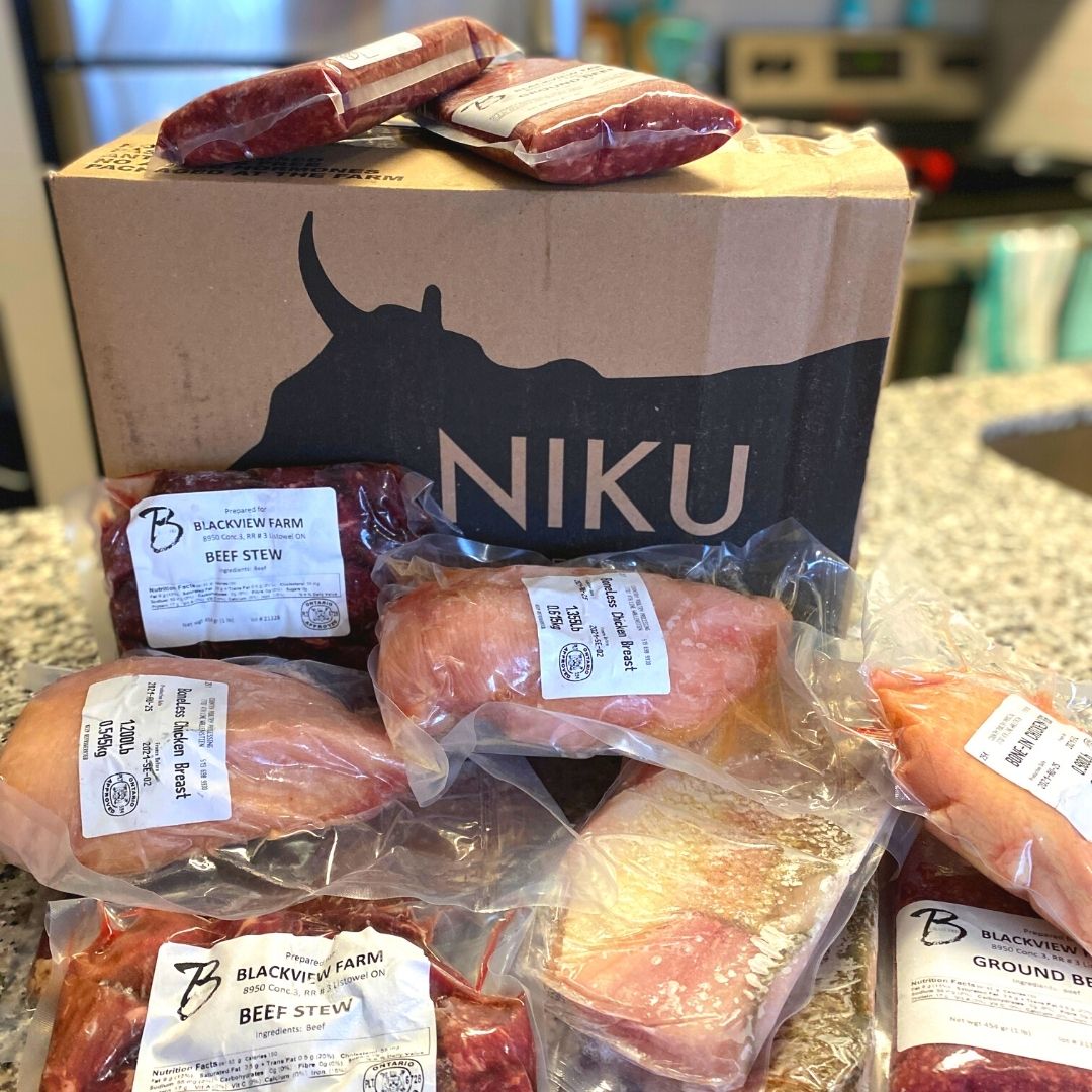 A NIKU Farms box with a variety of frozen pasture raised chicken and grass fed beef.