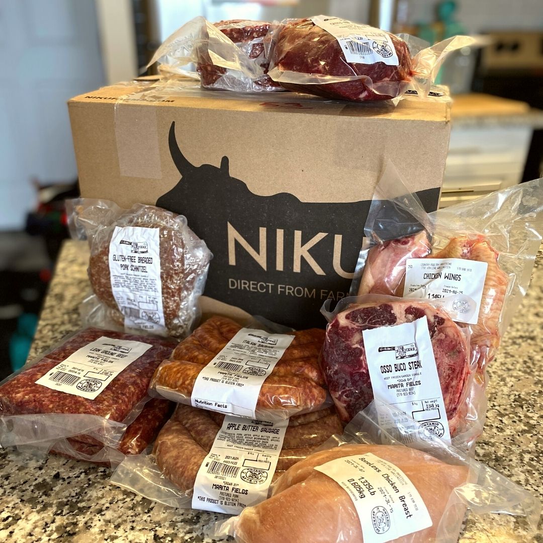 A NIKU Farms box on a countertop with a variety of flash frozen pasture raised meat surrounding the box.