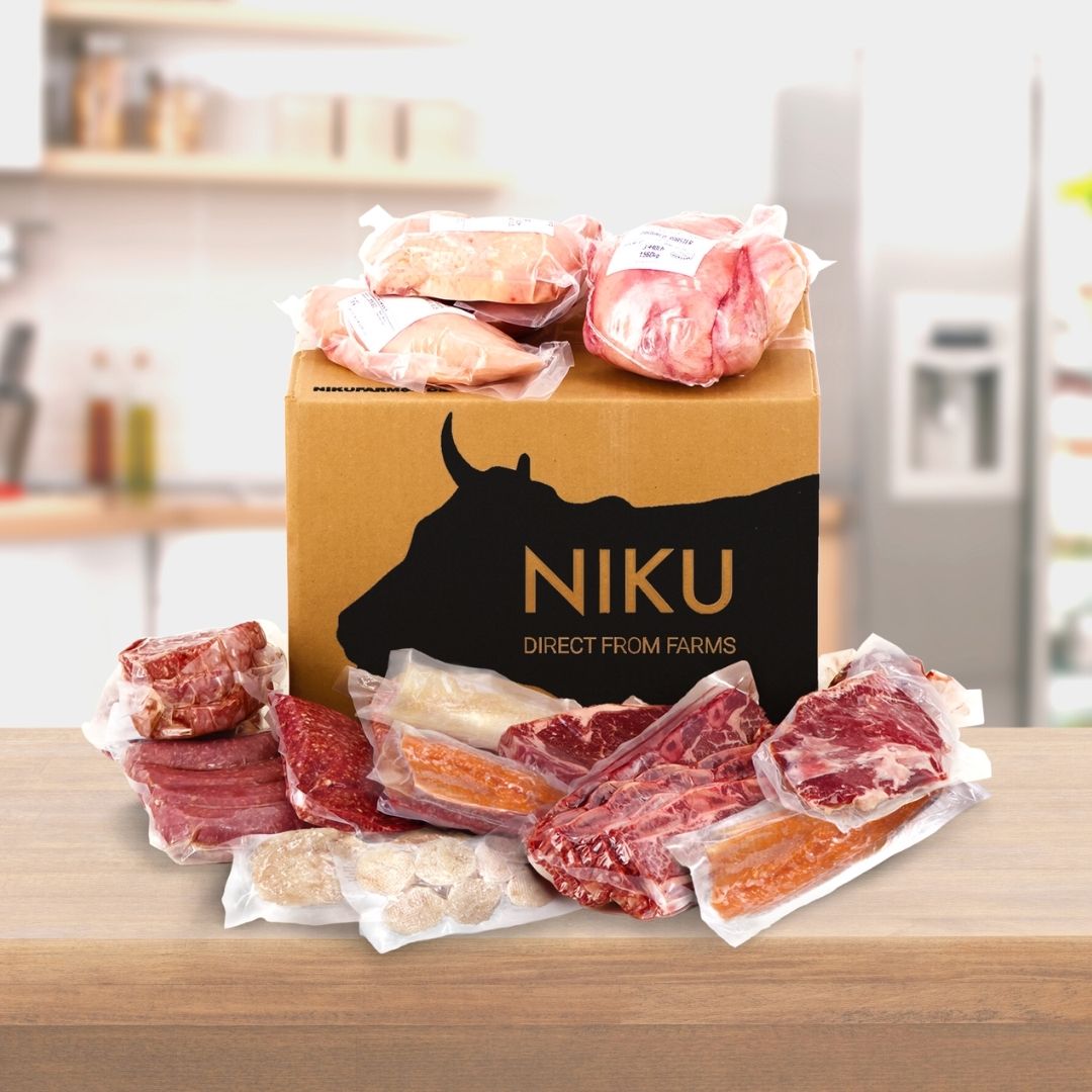 NIKU Farms box with packaged meat surrounding the box, placed on a kitchen counter.